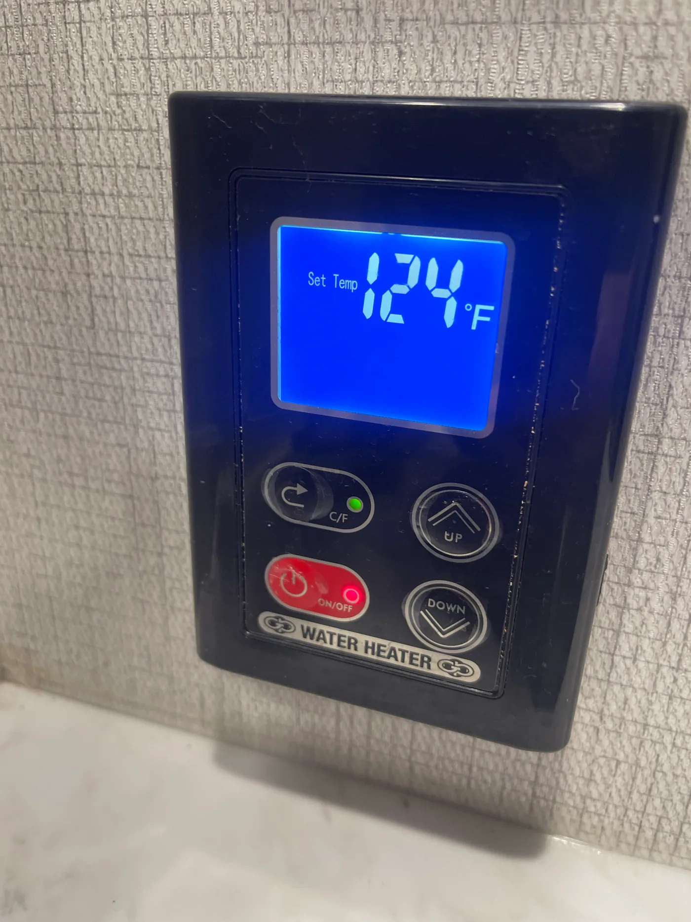 Girard tankless water heater wall control displaying a 124 degree Fahrenheit set temperature