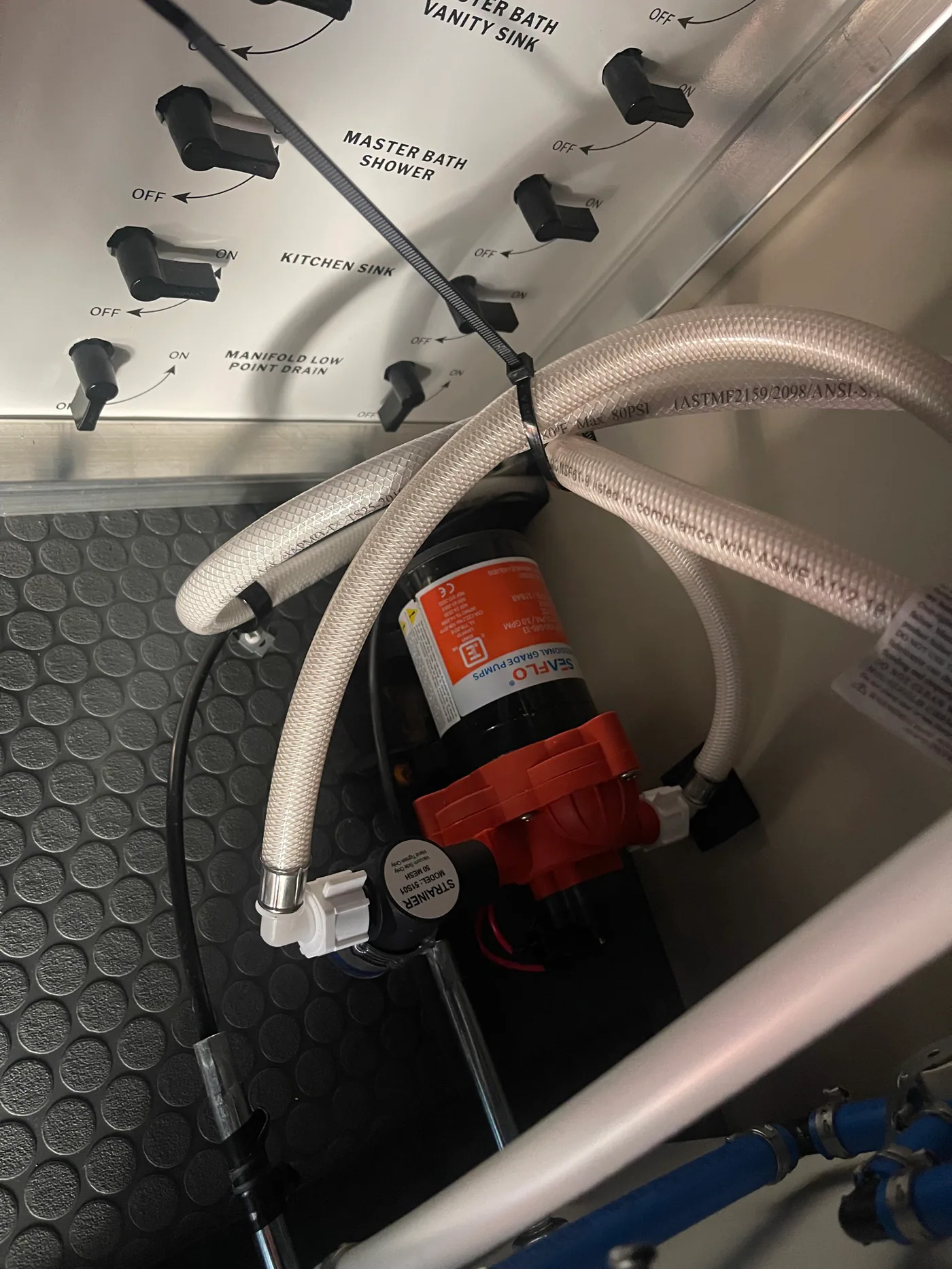 SeaFlo RV water pump below a labeled plumbing manifold with fixture isolation valves